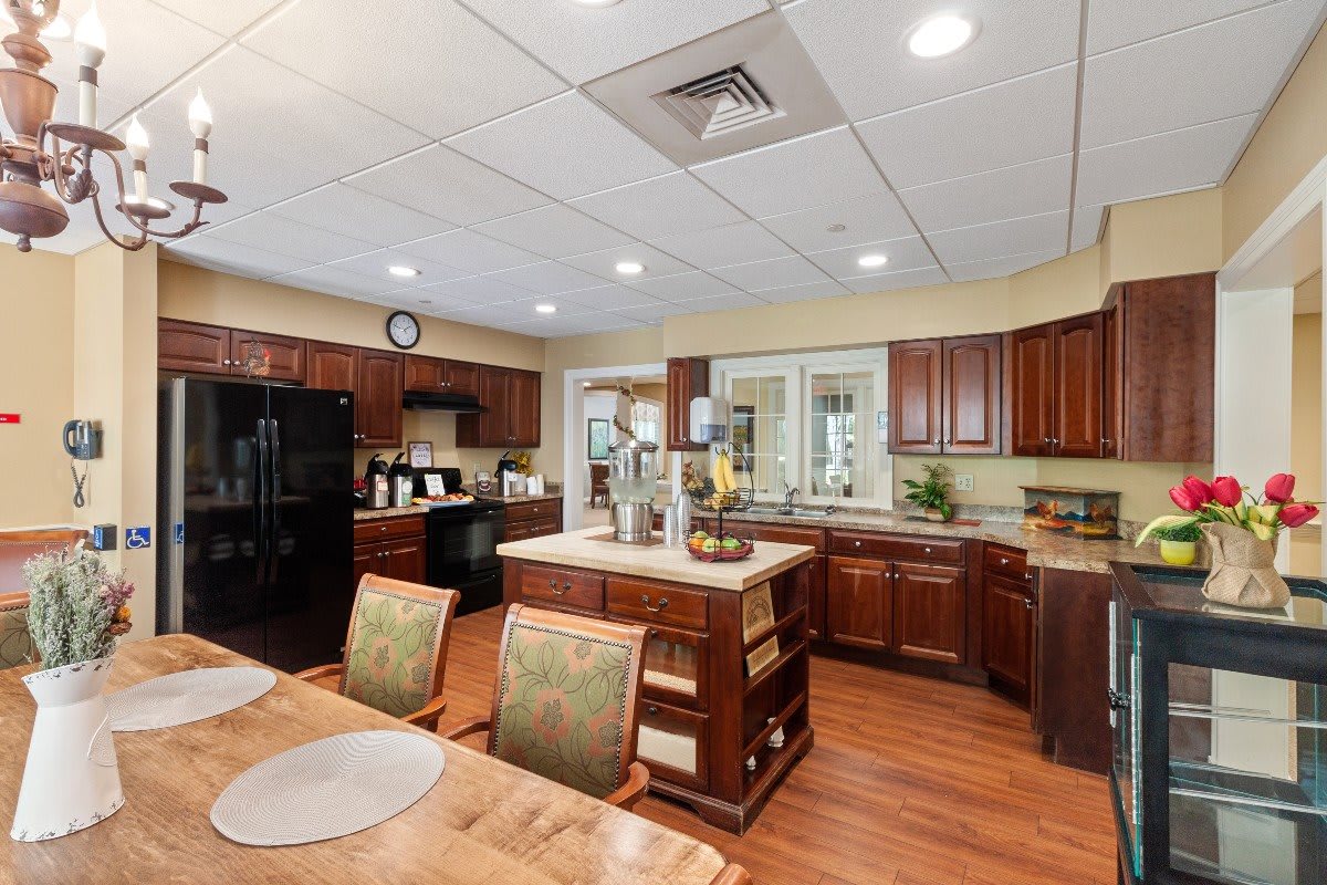 A spacious kitchen with wooden cabinets, an island counter, and dining area.