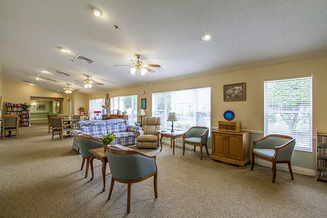 A spacious and well-lit lounge area with comfortable seating and large windows.