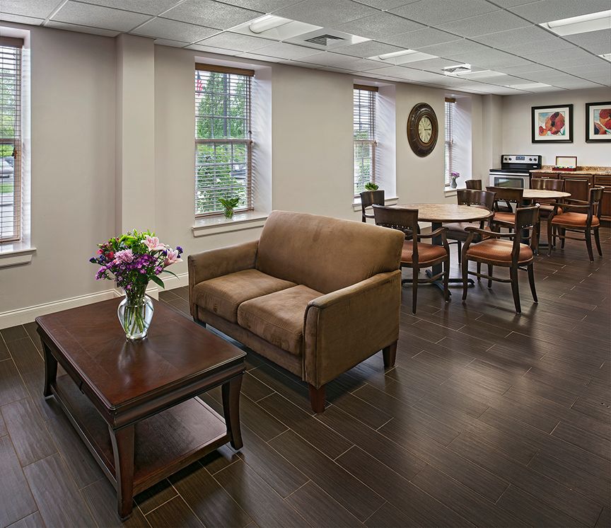 A cozy lounge area with a sofa, coffee table, and dining tables.