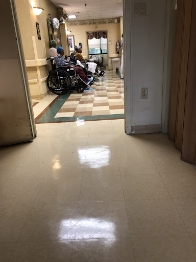 A view of a hospital hallway with patients and wheelchairs.