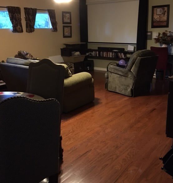 A cozy home theater setup with comfortable seating and a large projector screen.