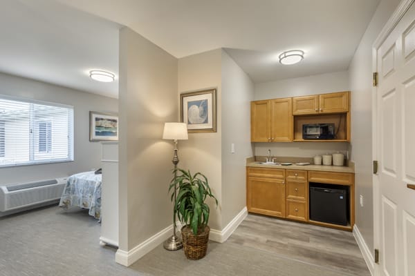 A compact apartment interior featuring a kitchen area, bedroom, and tasteful decor.