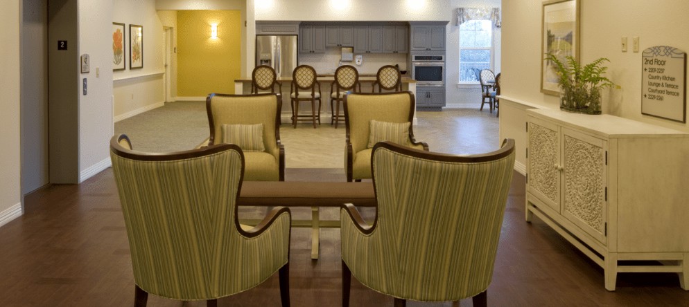 A modern kitchen and dining area featuring elegant chairs and a wooden table, with an open layout.