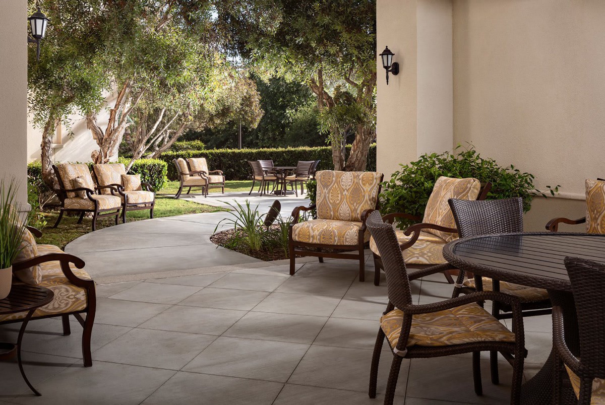 A tranquil patio area with comfortable seating surrounded by lush greenery.