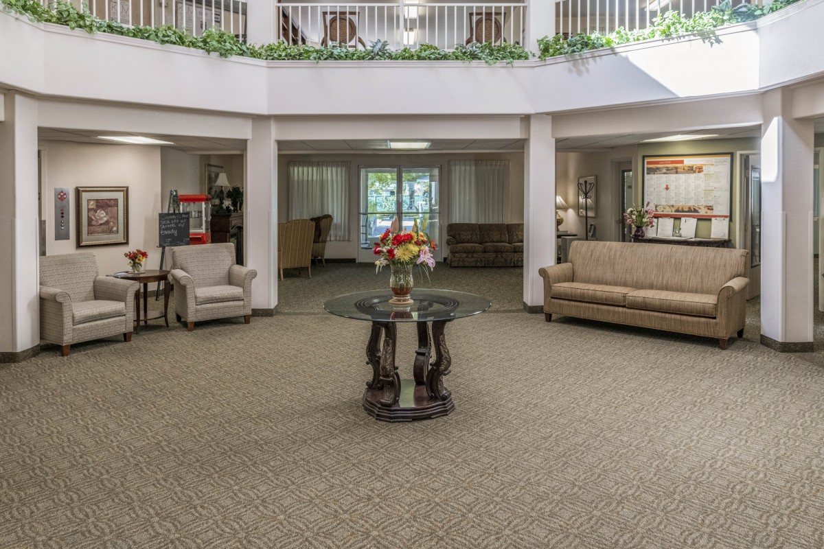 A spacious lobby area with comfortable seating and a central coffee table adorned with flowers.