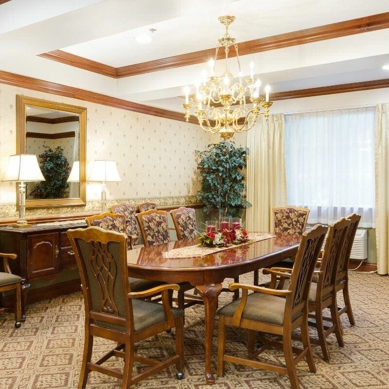 Elegant dining room with a large table and chandelier.
