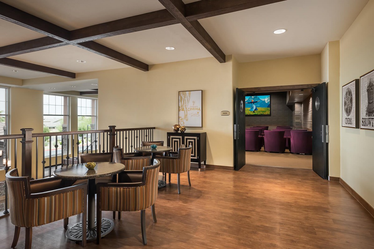 A modern lounge area featuring wooden floors, comfortable seating, and a television.