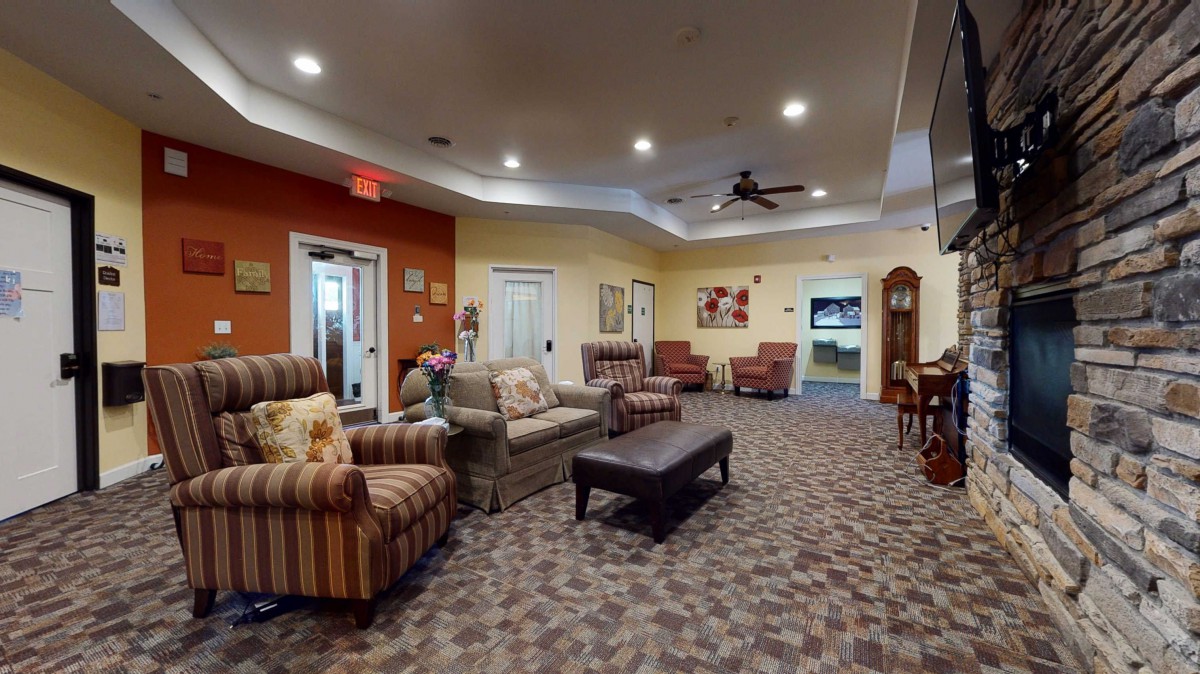 A cozy lounge area with comfortable sofas and armchairs, a coffee table, and warm lighting.