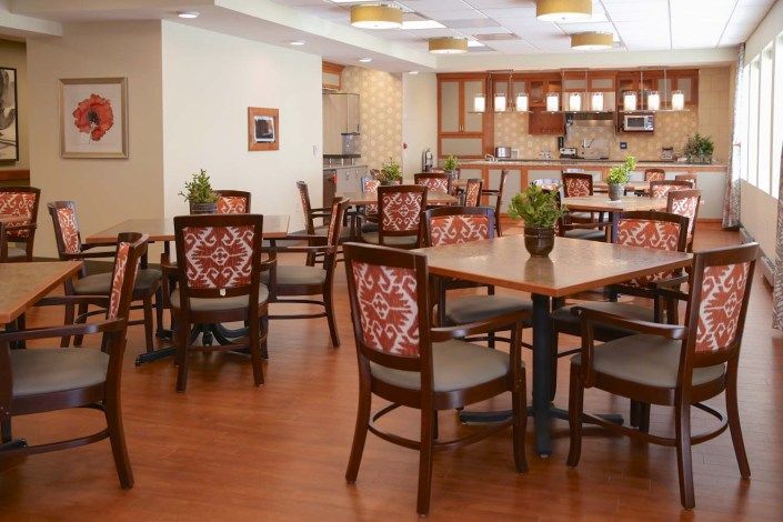 A spacious dining area with wooden furniture and a view of the kitchen.