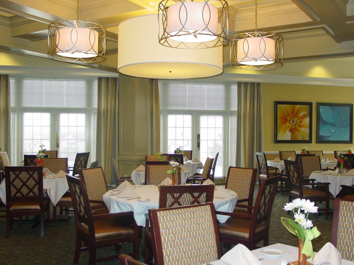 A well-lit dining room with neatly arranged tables and chairs, featuring elegant decor.