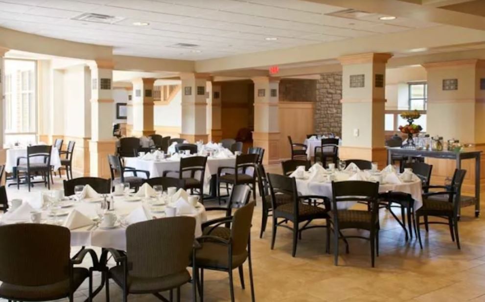 A formal dining room with tables set for guests.