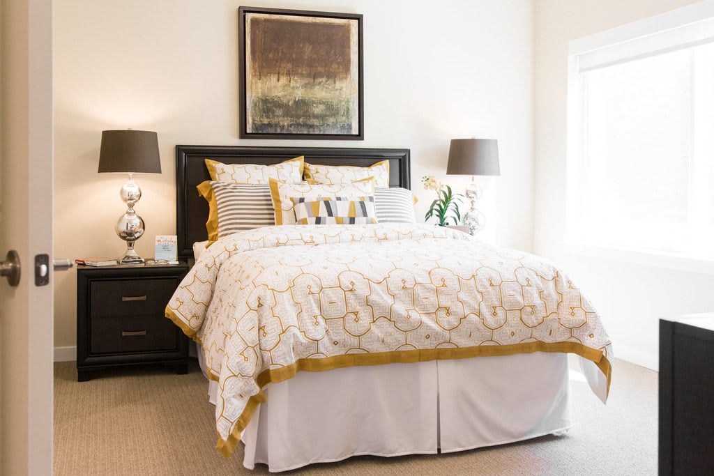A cozy bedroom with elegant bedding and tasteful decor.