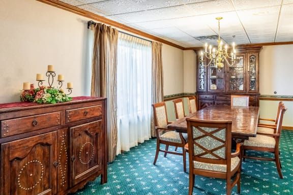 A traditional dining room with an elegant wooden table and chairs, adorned with a chandelier and classic decor.