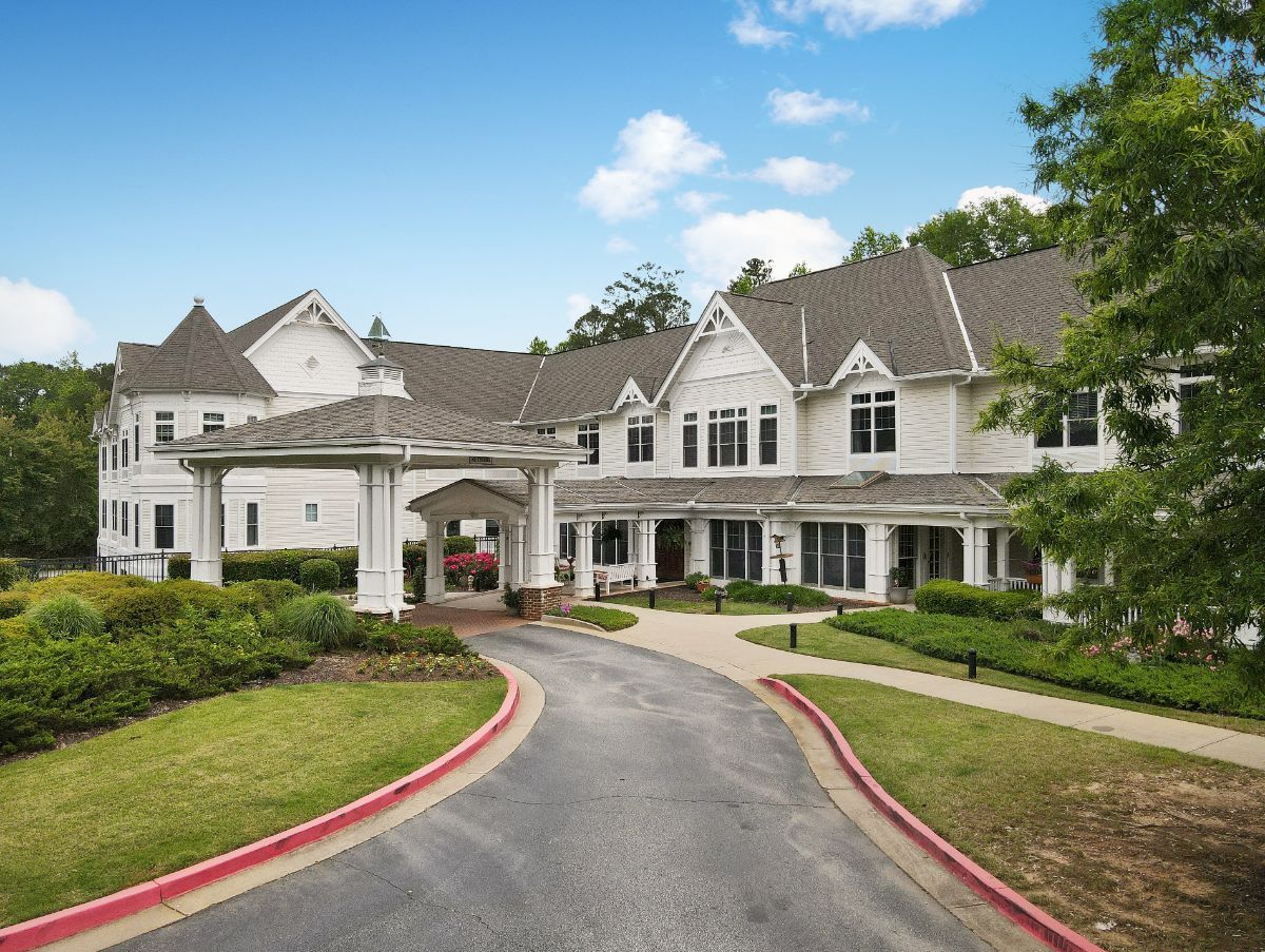 A large, elegant building with a welcoming driveway and landscaped surroundings.