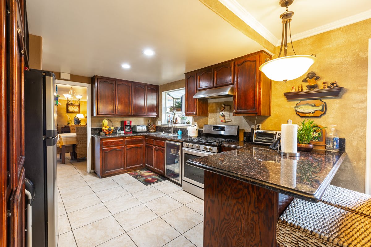 A modern kitchen with wooden cabinets and granite countertops.