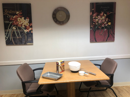 A cozy dining area featuring a table set with kitchenware and adorned with decorative wall art.