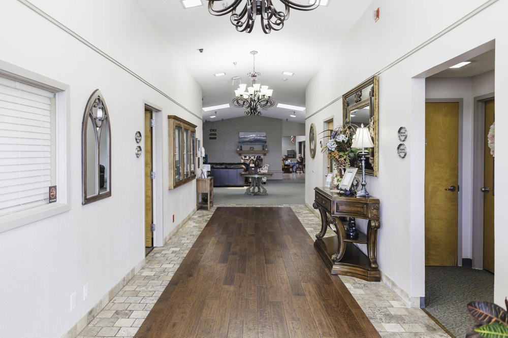 A beautifully decorated hallway with chandeliers, wooden floors, and mirrors.