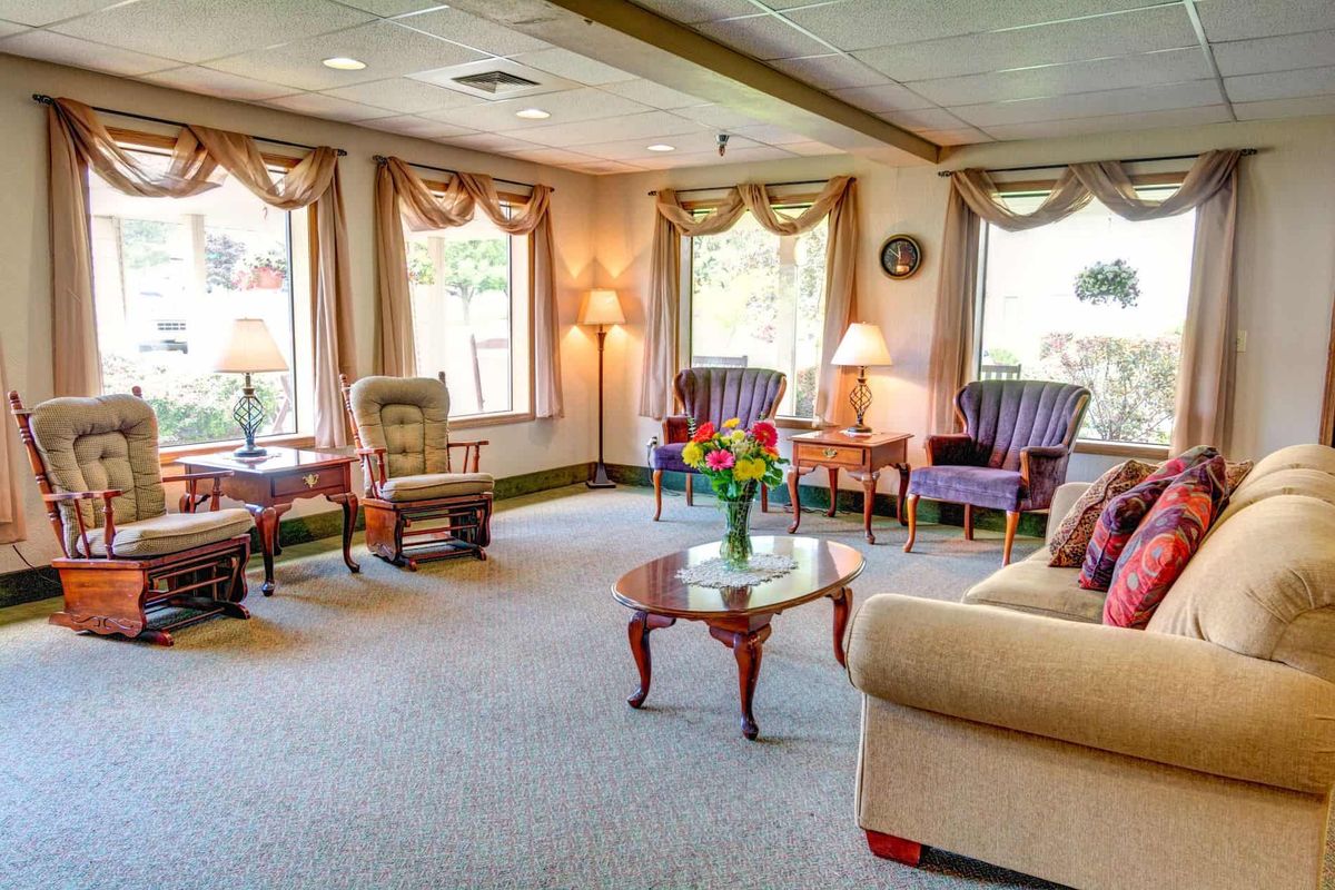 A cozy and well-furnished living room with sofas, chairs, and tables arranged in a welcoming setting.