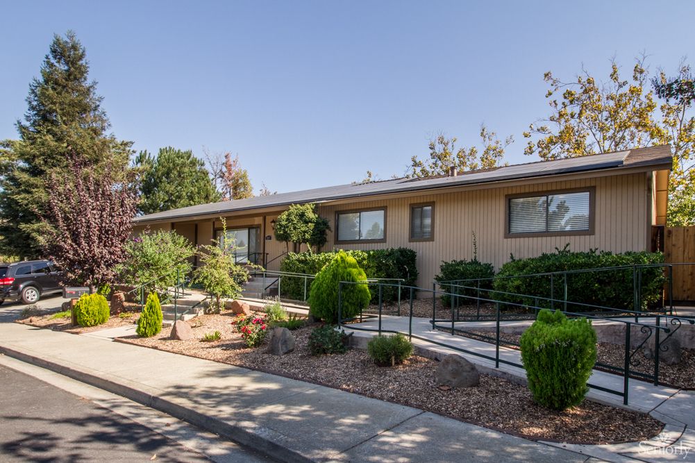 A single-story residential house with well-maintained landscaping and a sidewalk.