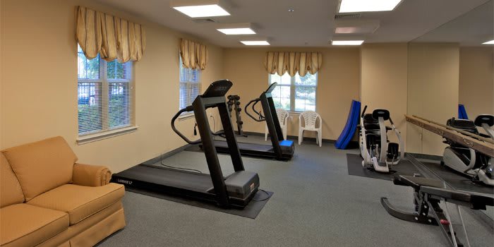 A small gym room featuring two treadmills and exercise equipment.