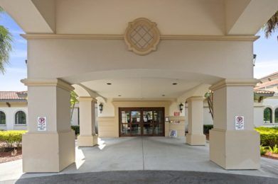 The entrance of a hotel with columns and decorative elements.