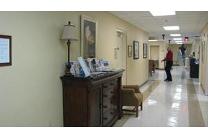 A hallway with decorative furniture and framed pictures.