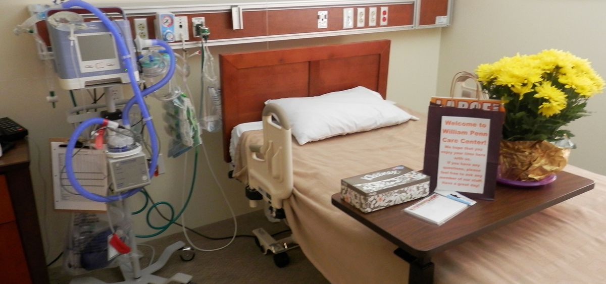 A hospital room with a bed and medical equipment.