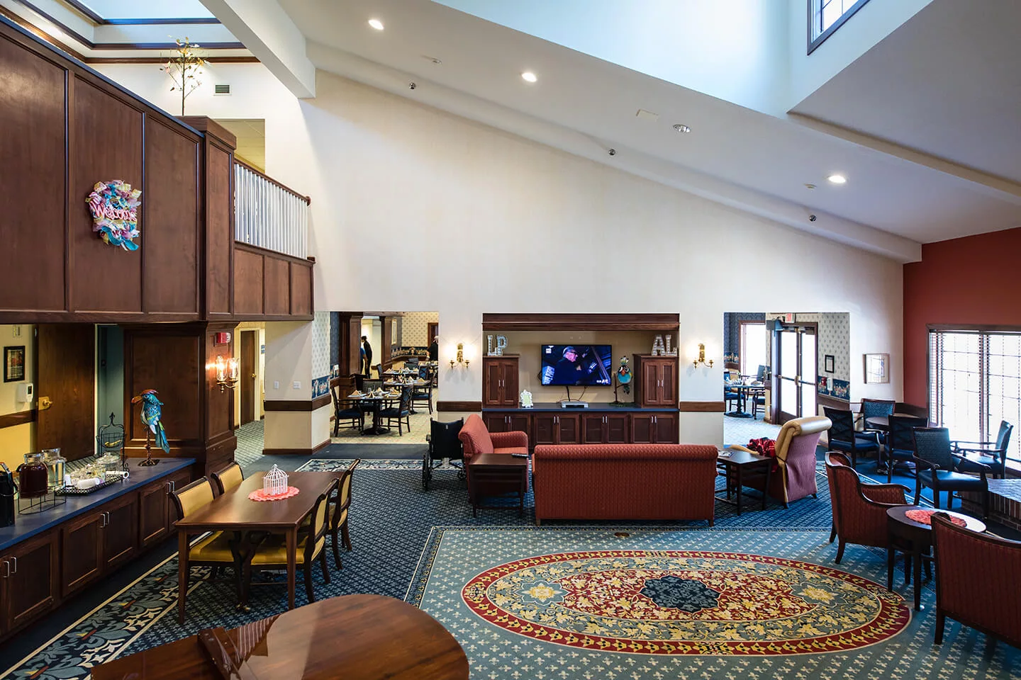 A spacious hotel lobby with comfortable seating and a large television.