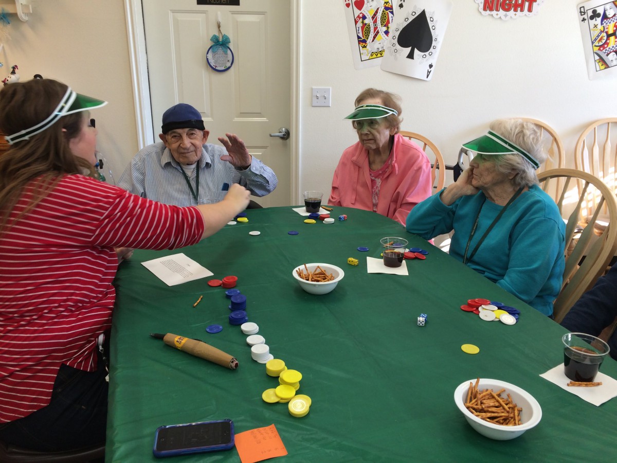 A group of seniors playing a card game with poker chips at a table.