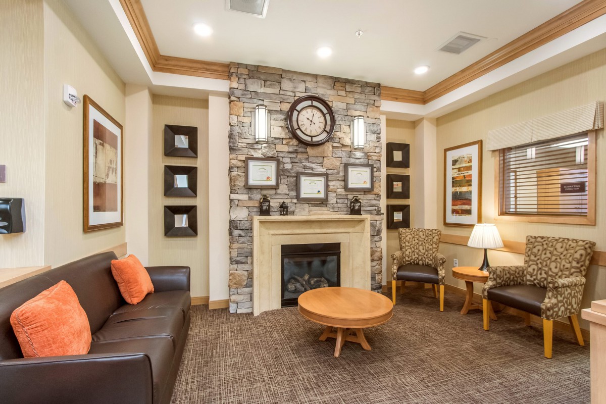 A cozy living room featuring a stone fireplace, comfortable seating, and warm lighting.