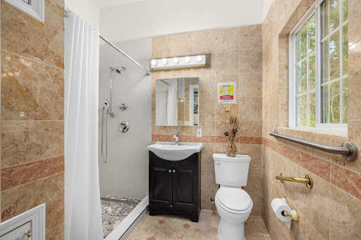 A compact and modern bathroom featuring a shower, toilet, and sink with elegant tile work.