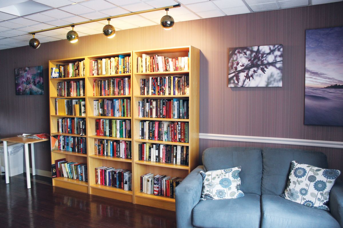 A cozy reading nook with a large bookshelf and comfortable couch.