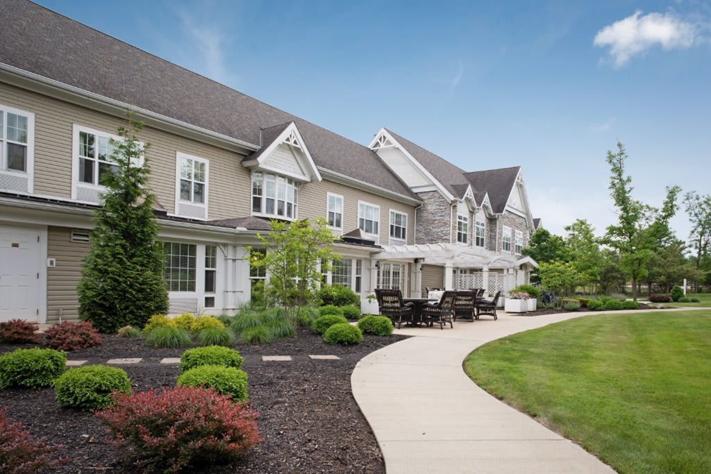A modern residential building with a well-maintained garden and a winding pathway.