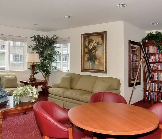 A cozy living room with comfortable seating, artwork, and a decorative plant.