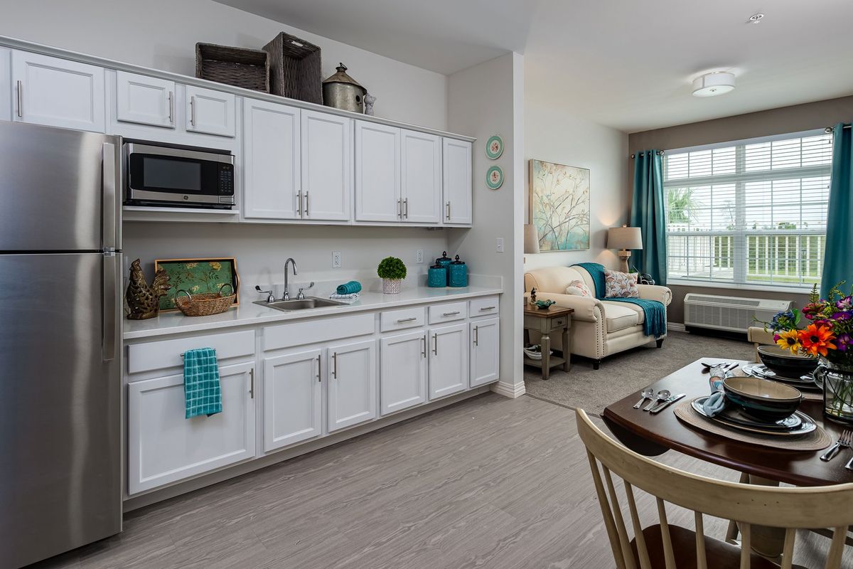 Modern open floor plan with a white cabinet kitchen and cozy living area.