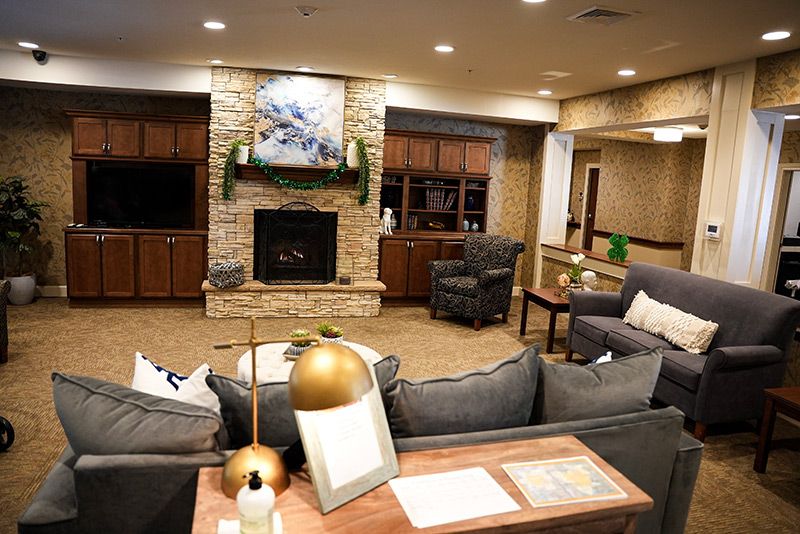 A cozy living room featuring modern decor with a central fireplace, comfortable sofas, and armchairs.