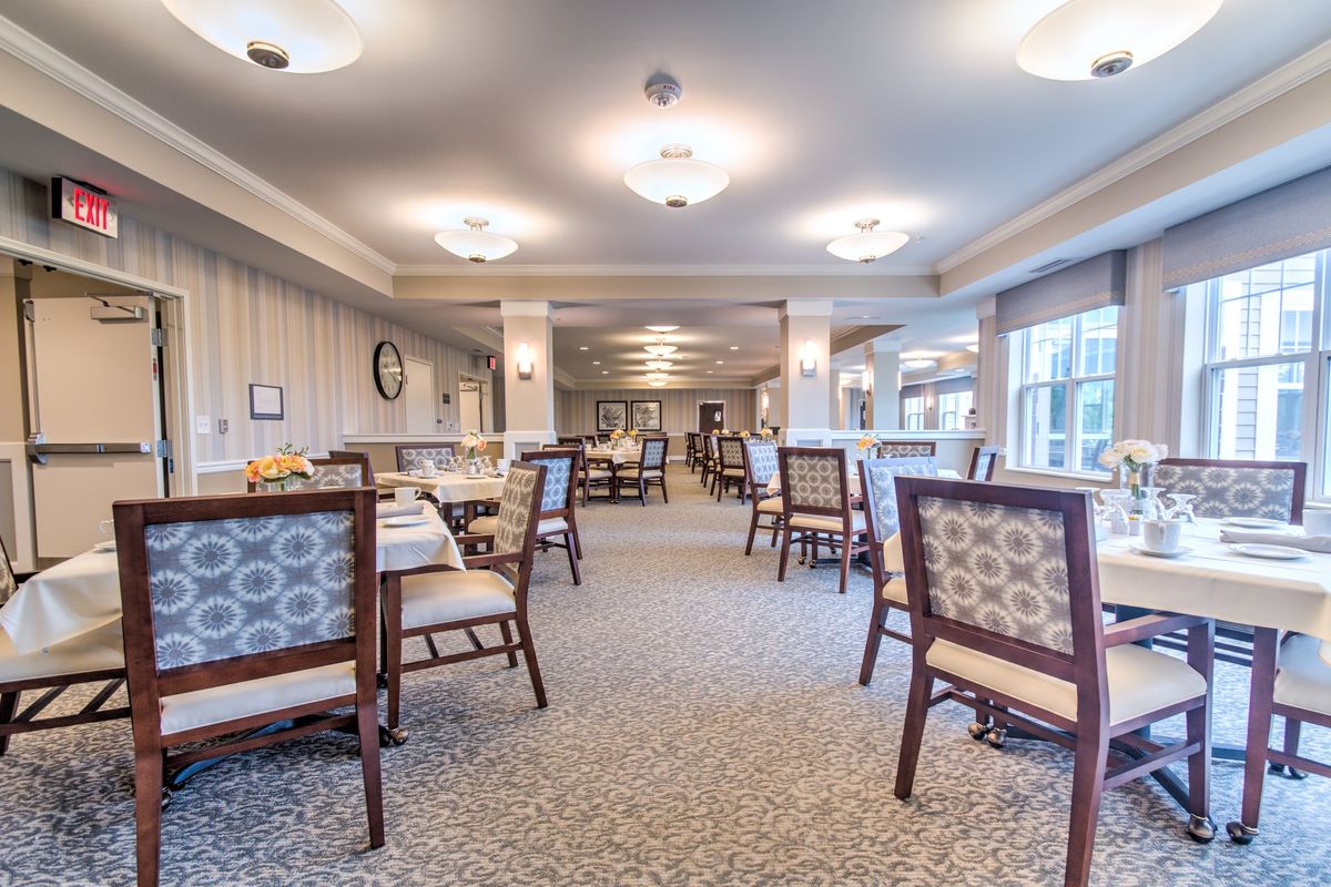 A spacious and elegantly designed dining area with neatly arranged tables and chairs.