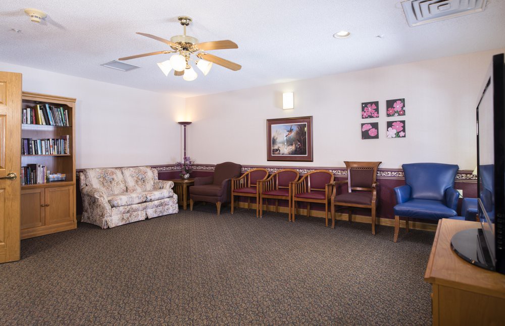 A quiet waiting room with various seating options and a ceiling fan.