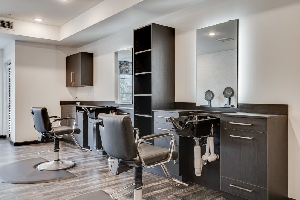 A modern hair salon interior featuring sleek chairs and mirrors.