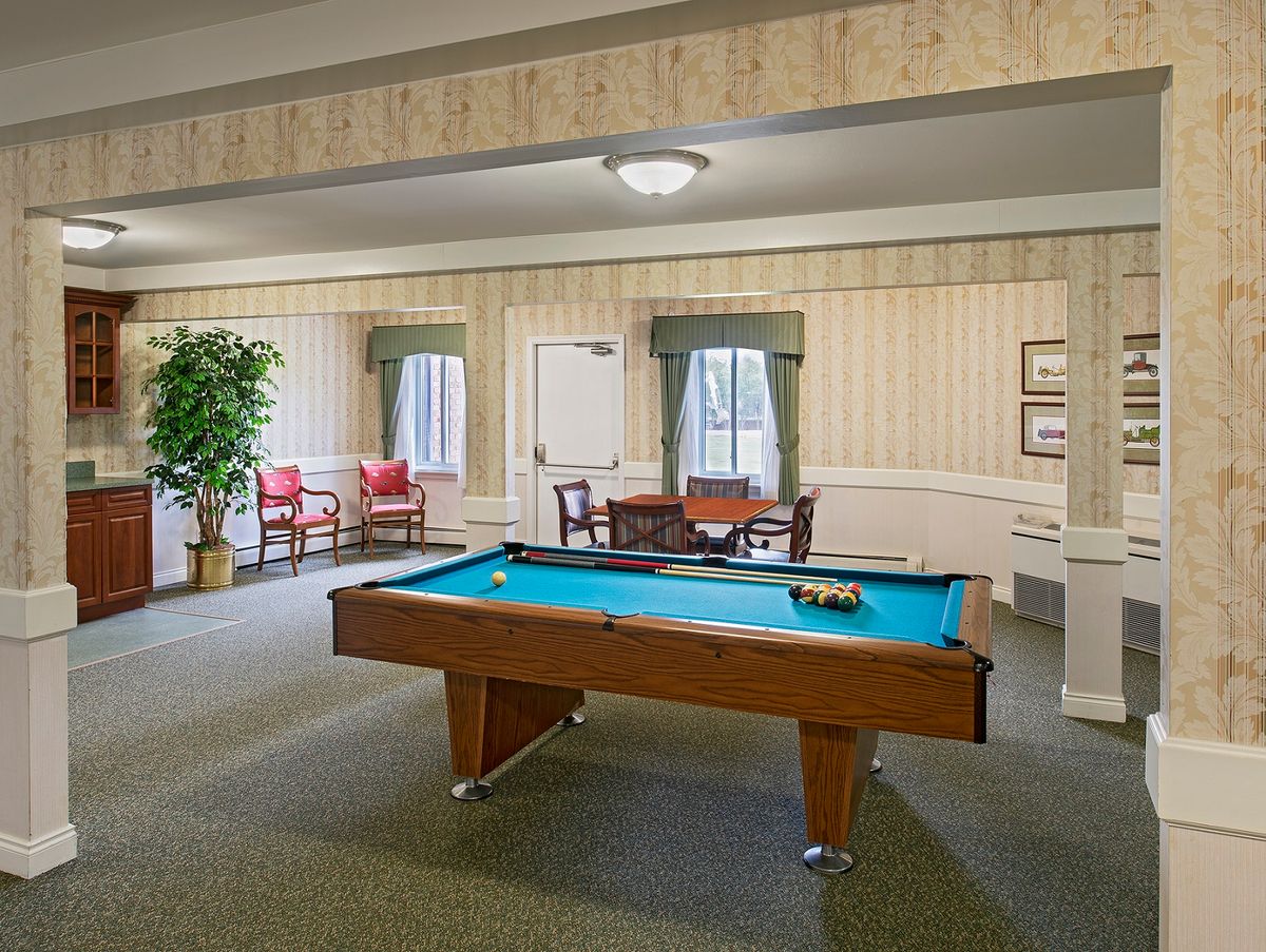 A cozy recreation room featuring a pool table and comfortable seating area.
