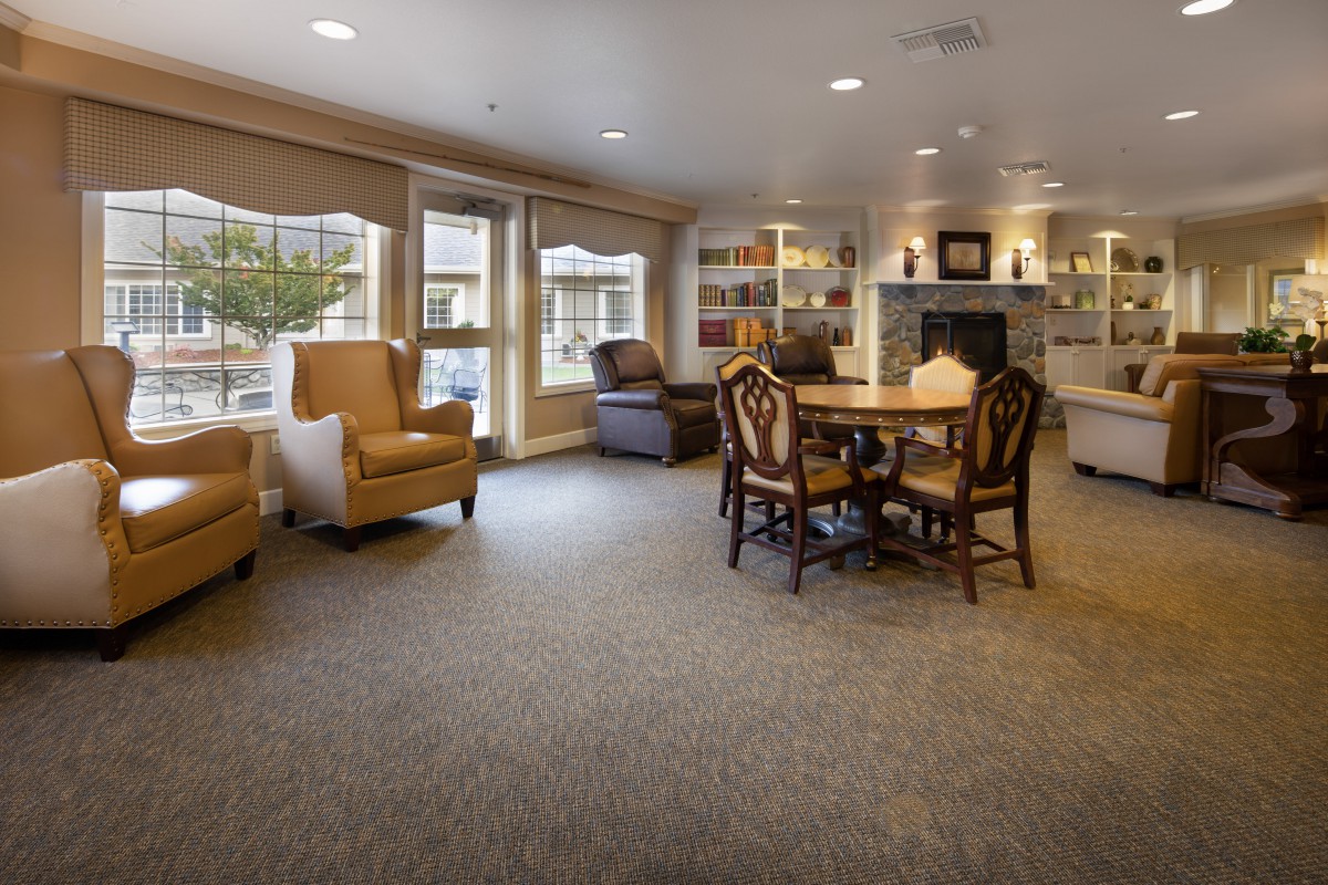 Cozy living room with comfortable seating, a fireplace, and a bookshelf.