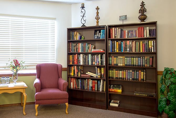 A cozy reading corner with a bookshelf filled with books and a comfortable armchair.