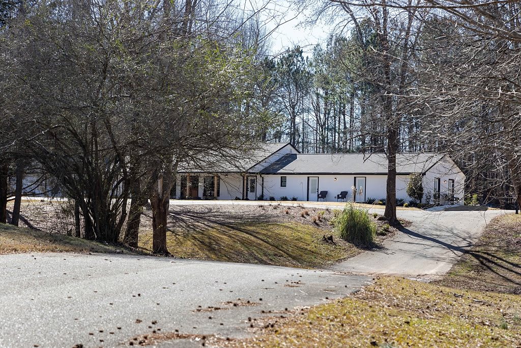 A suburban house surrounded by trees with a winding driveway.