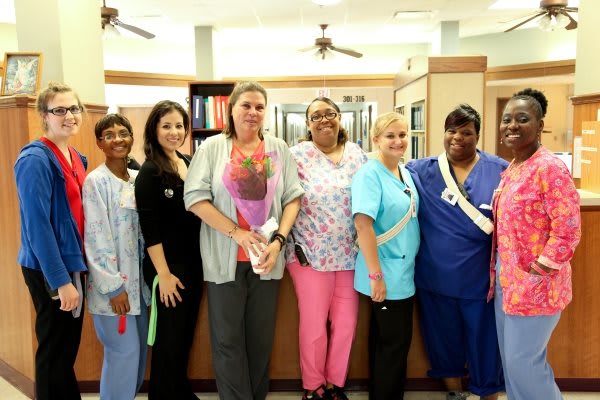 A group of nurses posing together in a hospital setting.