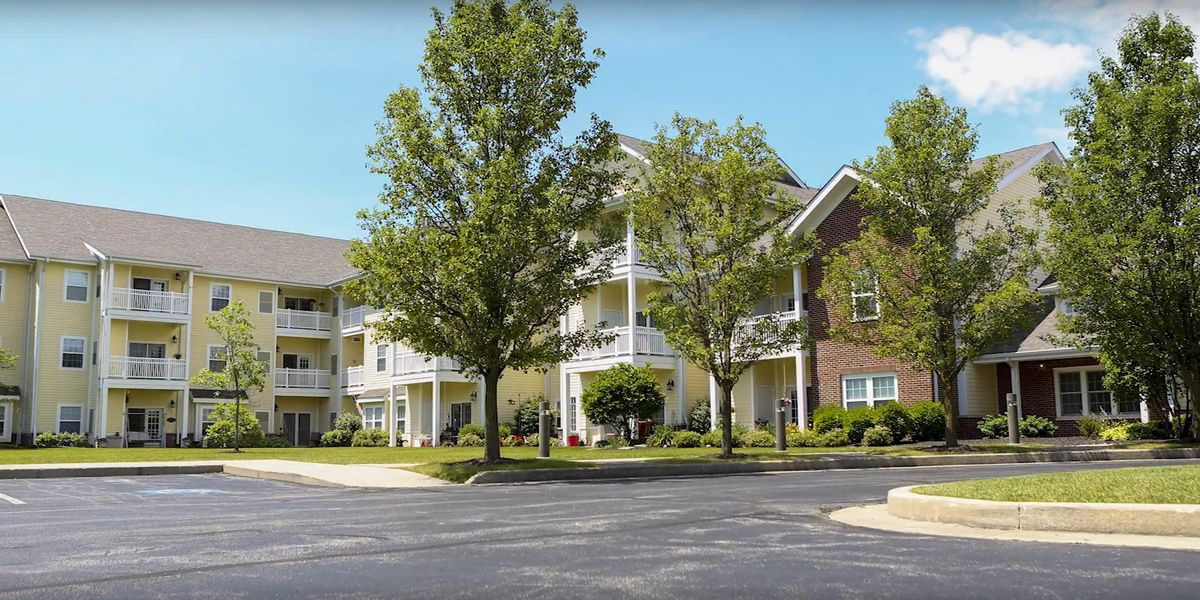 A residential apartment complex with trees and well-maintained landscaping.