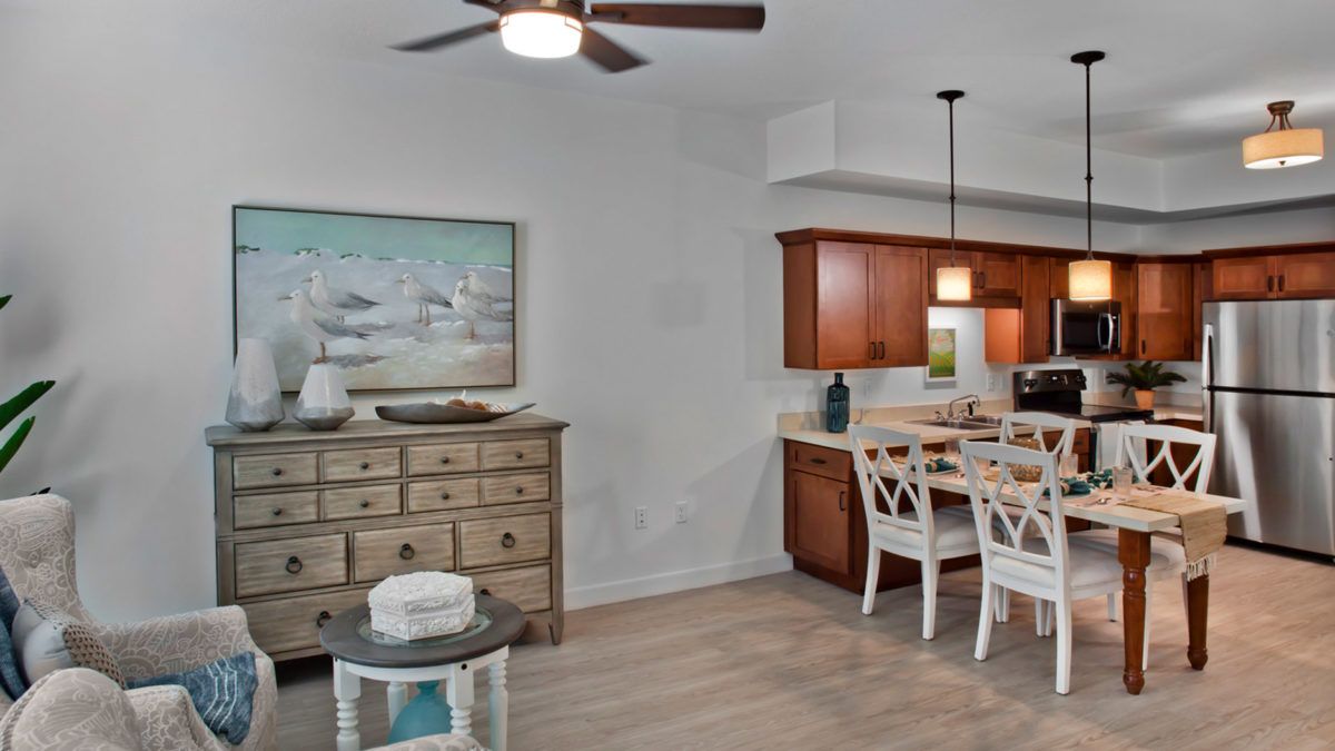 A cozy dining area with wooden cabinets, a ceiling fan, and stylish decor.