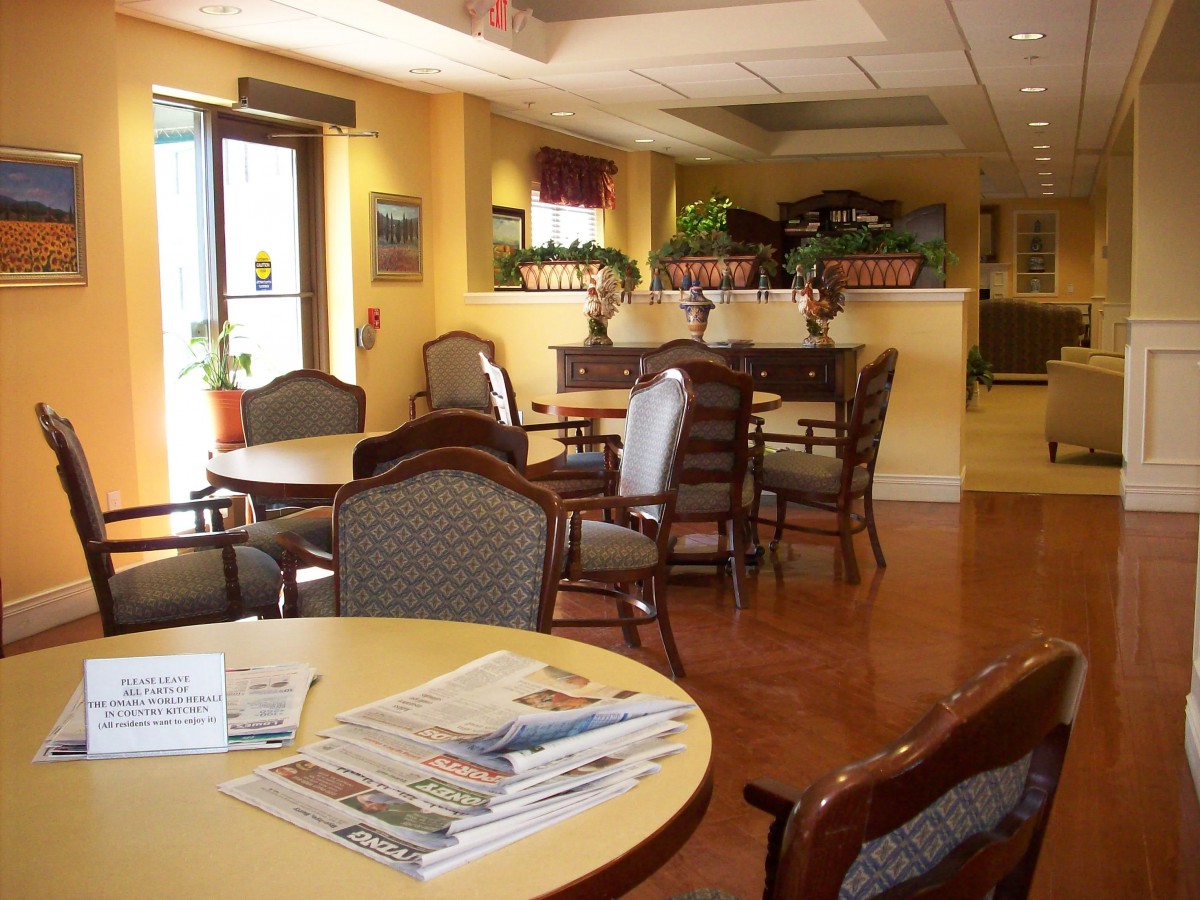 A cozy waiting room with tables, chairs, and magazines.