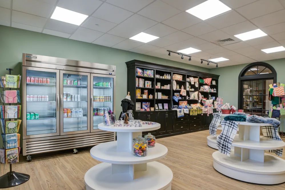 A well-organized retail store interior with shelves full of various products and a refrigerator on one side.