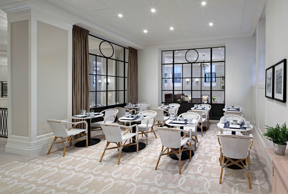 A modern and elegantly designed restaurant dining area with neatly arranged tables and chairs.