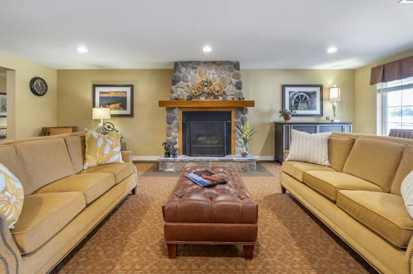 A cozy living room with a fireplace, two sofas, and a central coffee table.